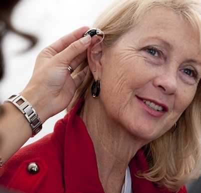 Woman Getting Fitted For Hearing Aid Device